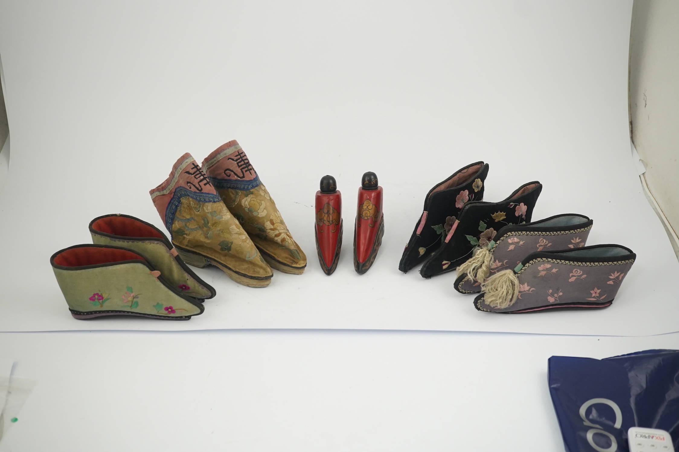 Three pairs of late 19th / early 20th century Chinese ladies embroidered silk shoes, for bound feet, one with sheep’s wool pom-poms, together with a similar a pair of silk embroidered ankle boots and pair of decorative r